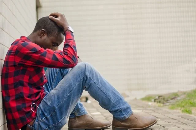 A man in a plaid shirt sitting down