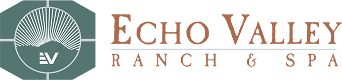 Logo for Echo Valley Ranch & Spa featuring a stylized sun rising over hills.