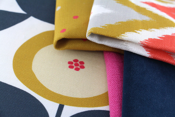 Close-up of folded colorful fabric pieces with floral and geometric patterns.