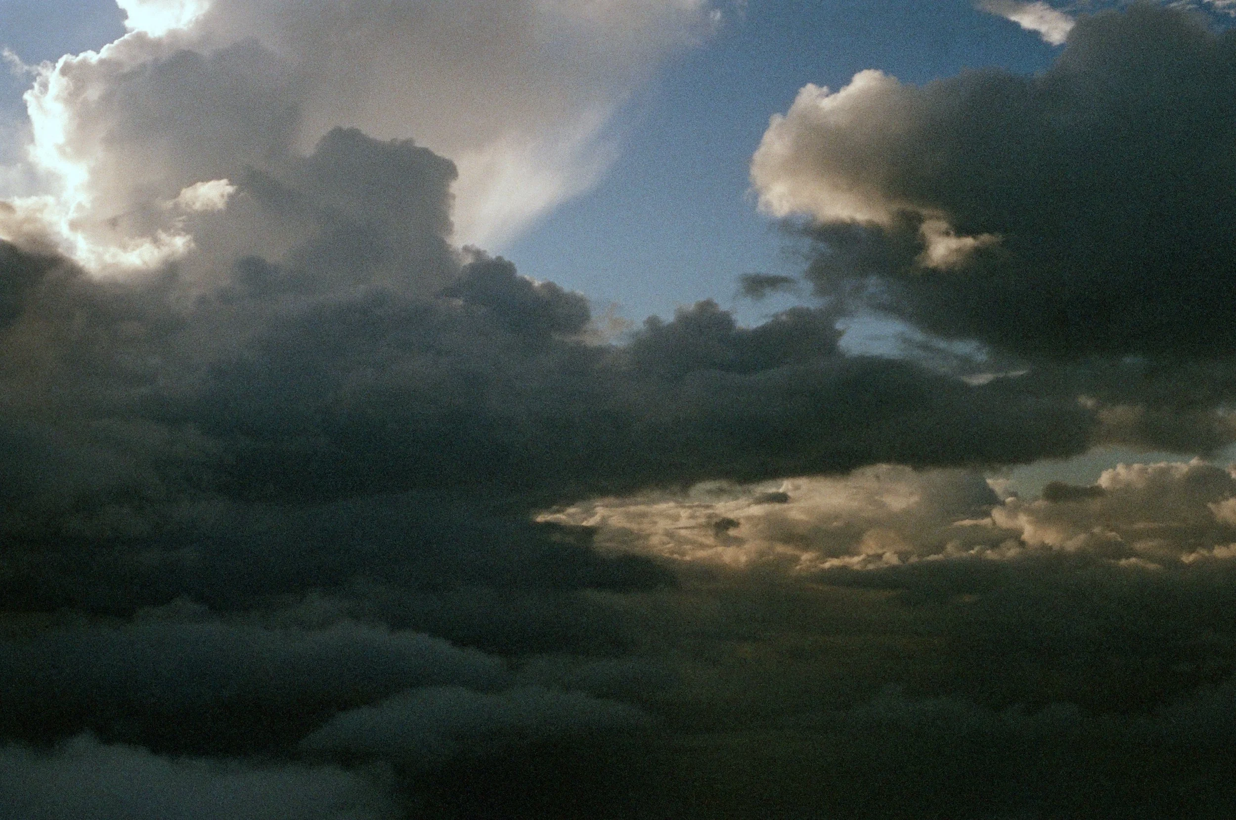 Dark storm clouds covering the sky with a small patch of blue sky visible in the background