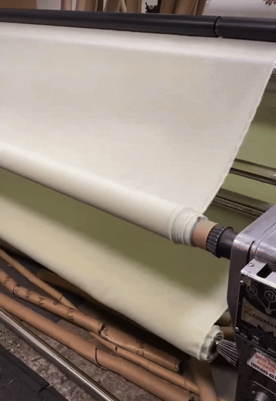 A printer rolling out large sheets of fabric or material.