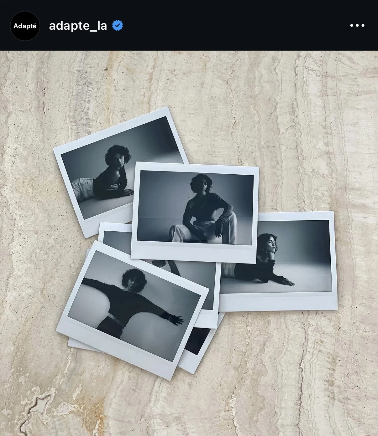 Several black and white photographs of a woman in various poses are scattered on a light-colored marble surface.