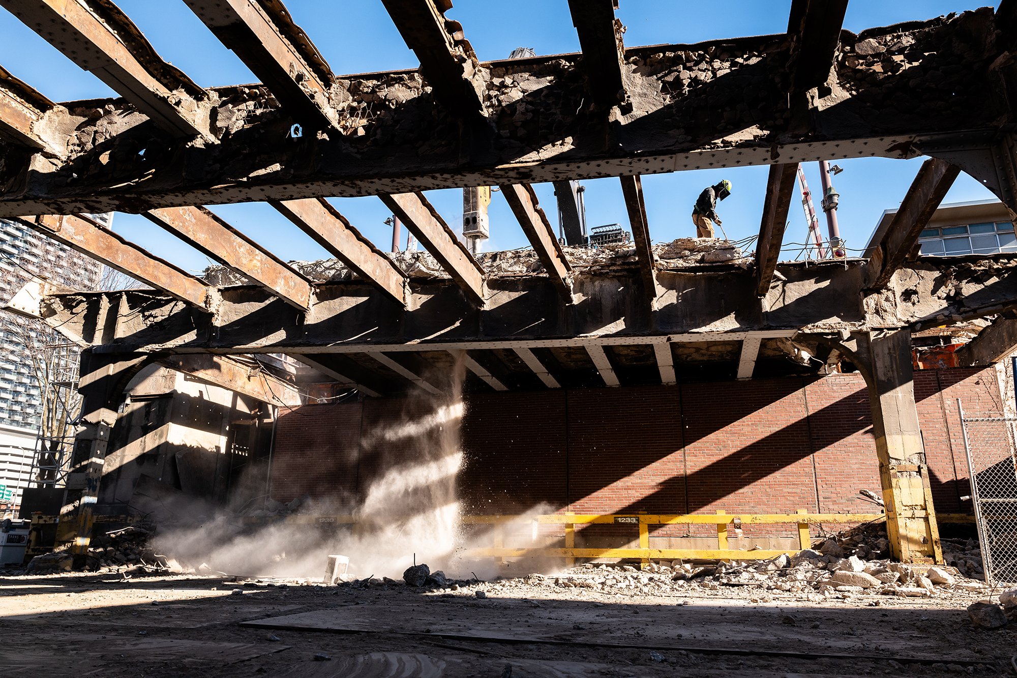bridge demolition with machine and human with a cutting torch