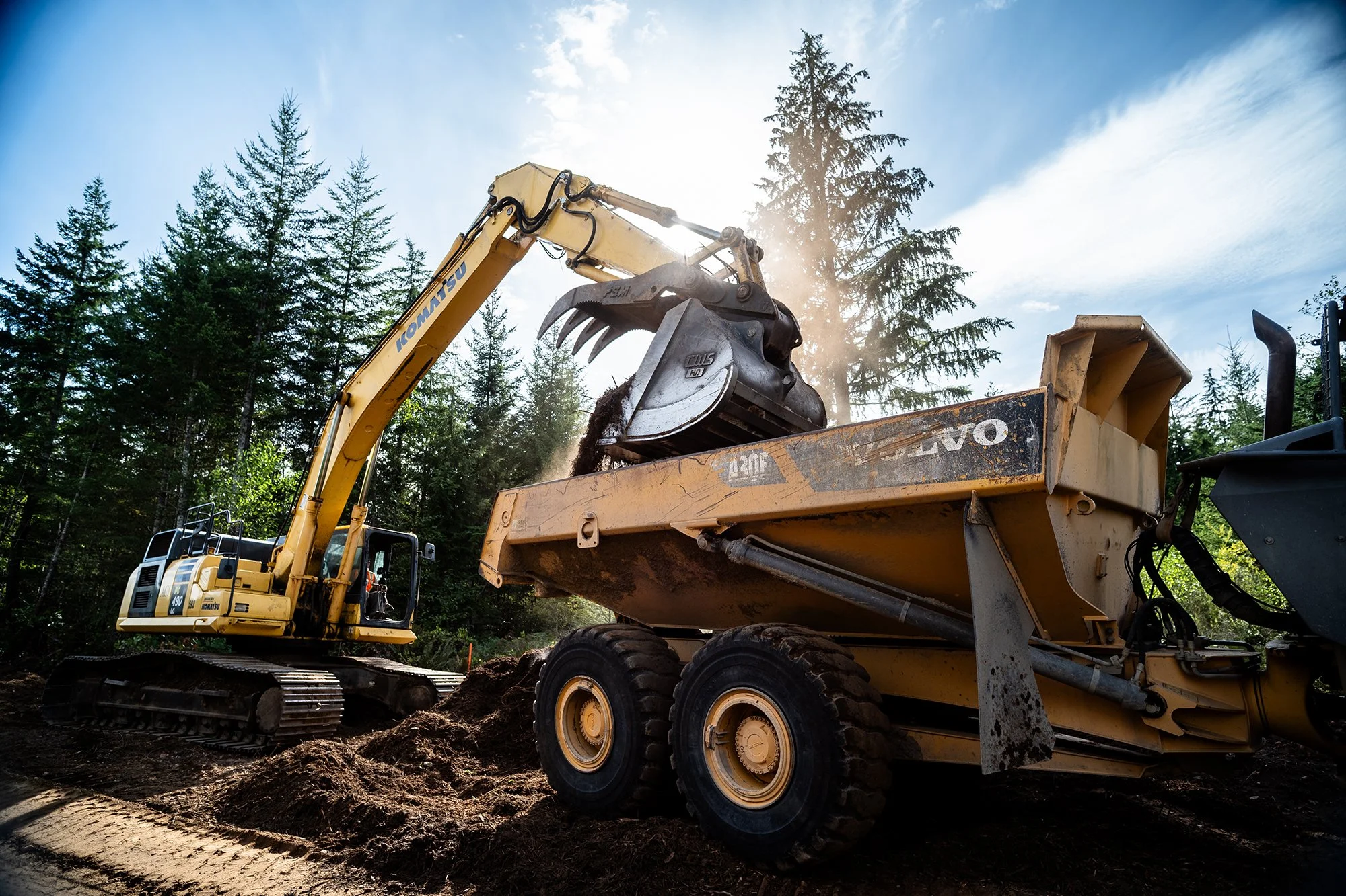 excavator loading dirt into haul truck