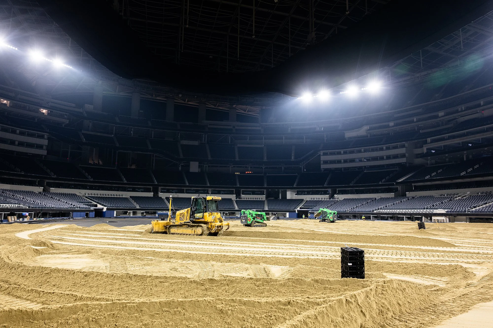 bulldozer and skid steers pushing sand in sofi stadium