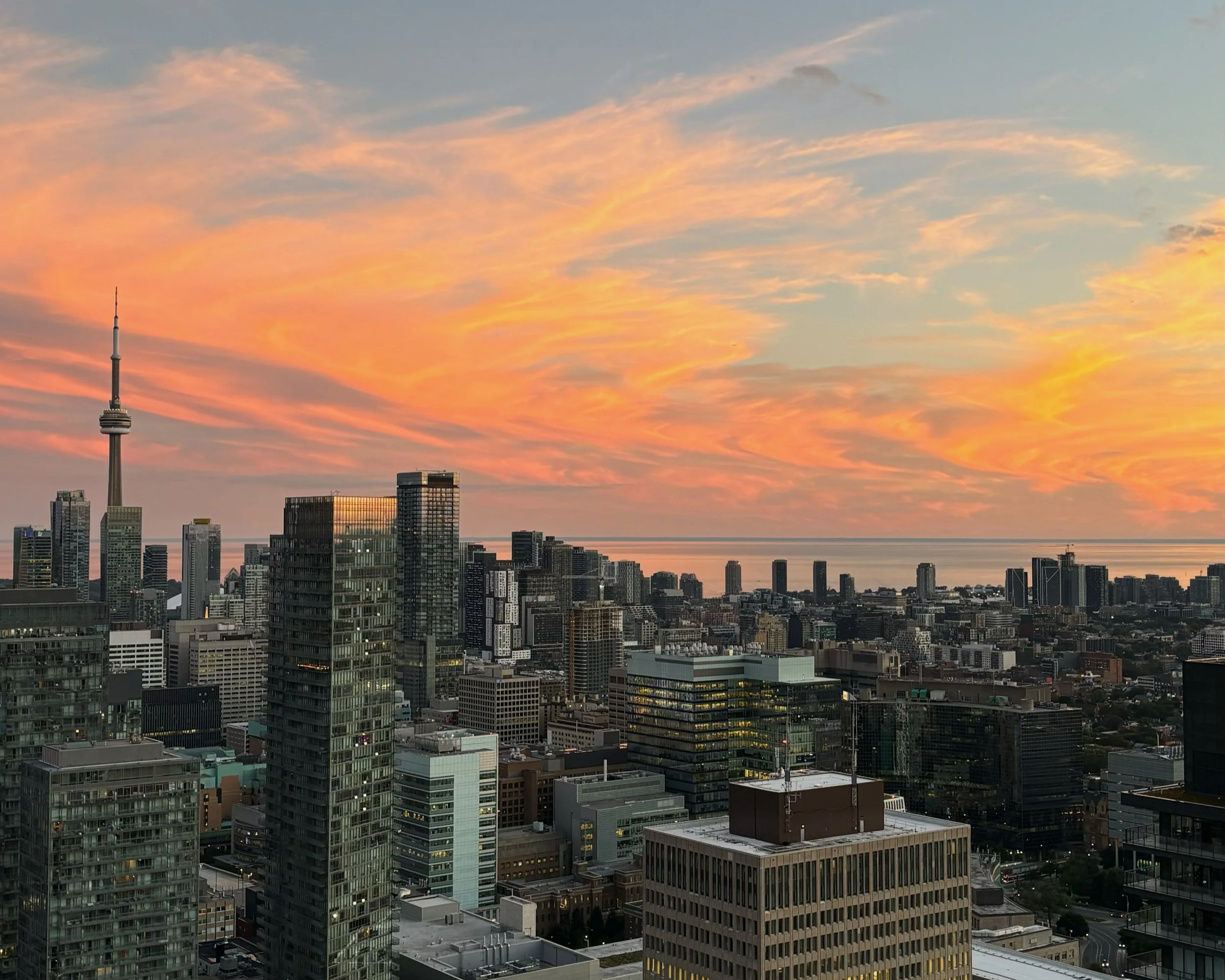 Toronto skyline during sunset with pink and orange clouds