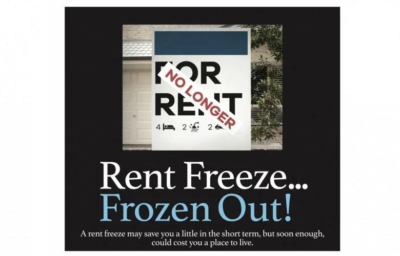 A sign with a message about rent freezing and it being frozen out, with the phrase "NO LONGER" in red and "RENT FREEZE" in black. The sign includes icons of a bed, a fire, and a house, and is placed on the driveway of a house.