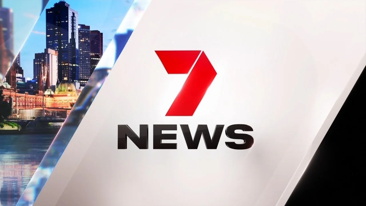 7 News logo with a city skyline in the background.