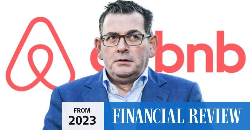 A man wearing glasses and a blue suit jacket stands in front of a background with the Airbnb and Bnb logos. There is a sign that reads 'From 2023 Financial Review'.
