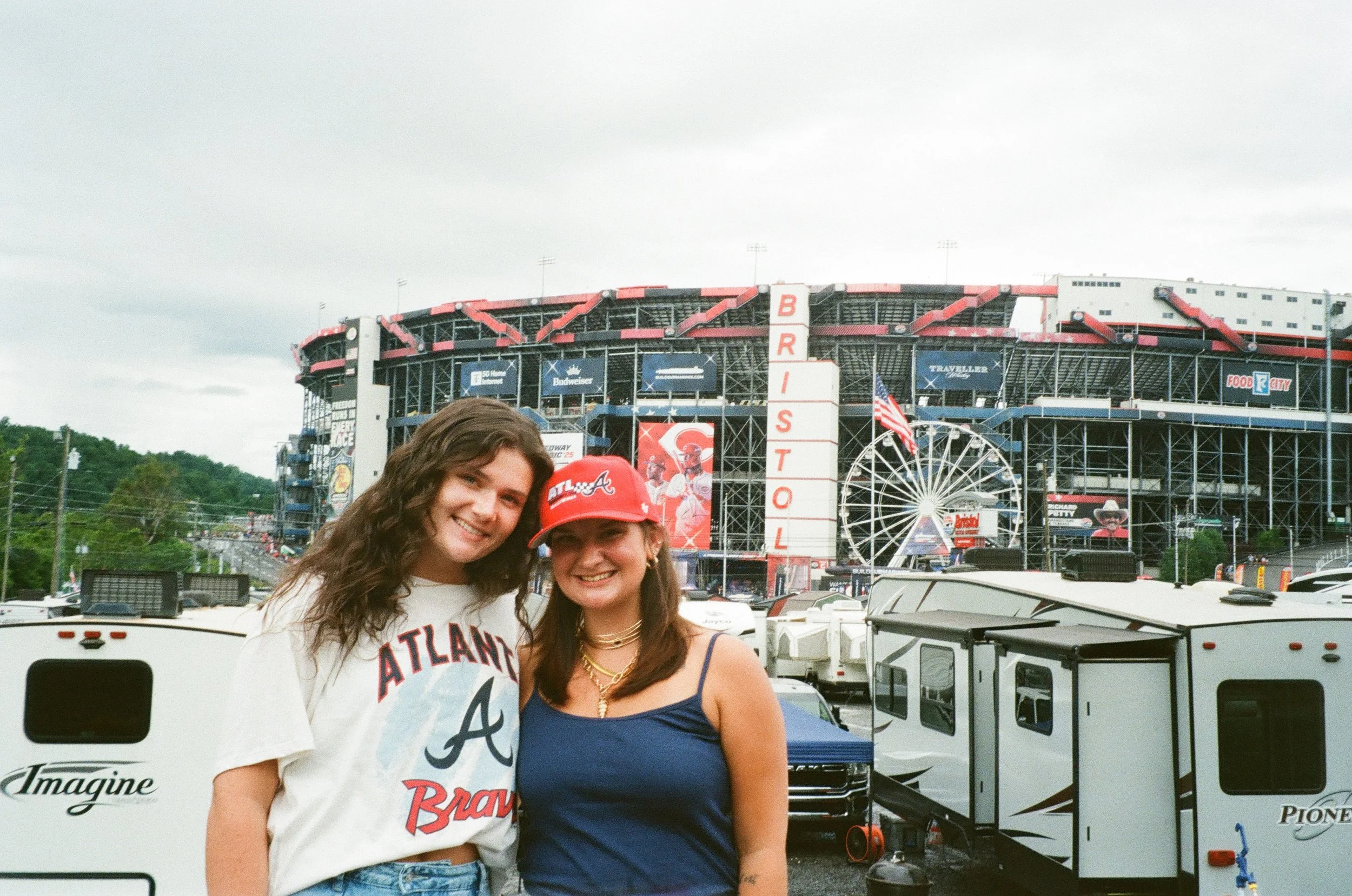 A film photo of Marlee and a friend standing in front of Bristol Motor Speedway.