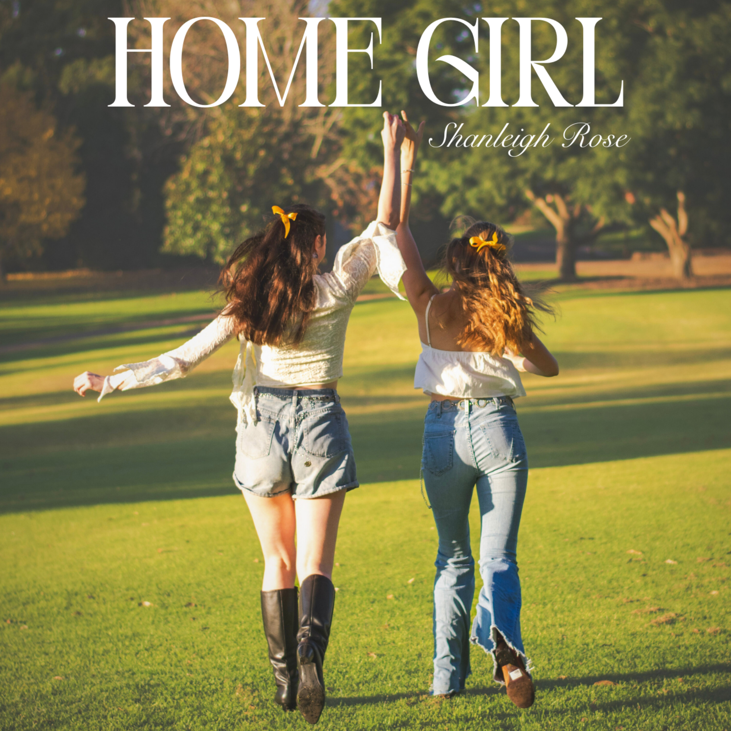 "Home Girl" cover art featuring two women walking through a park on a sunny day, with their backs to the camera, raising one arm together.