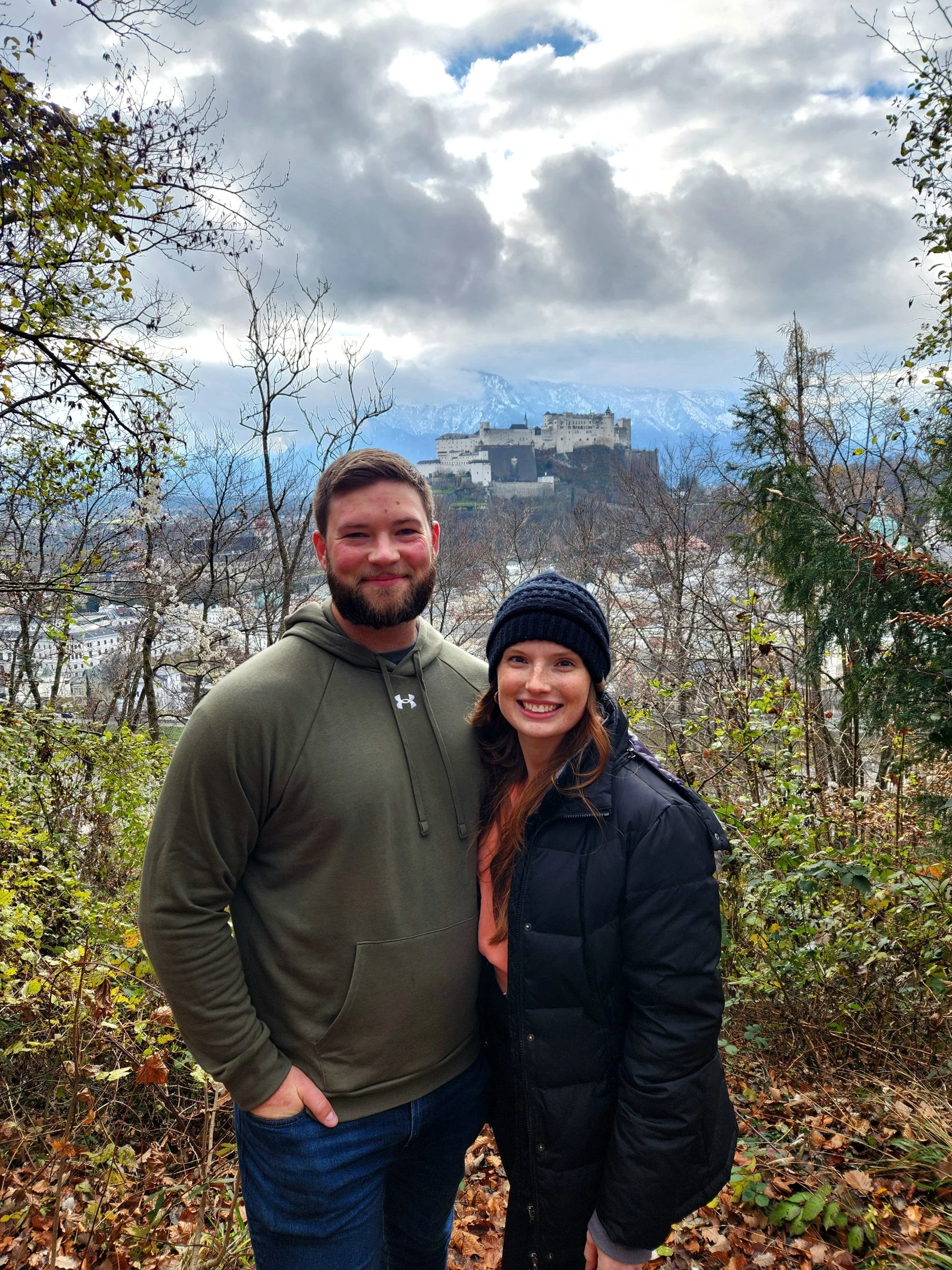 Nick and Brooke hiking Kapuzinerberg with views over Salzburg and Hohensalzburg Fortress in the background.