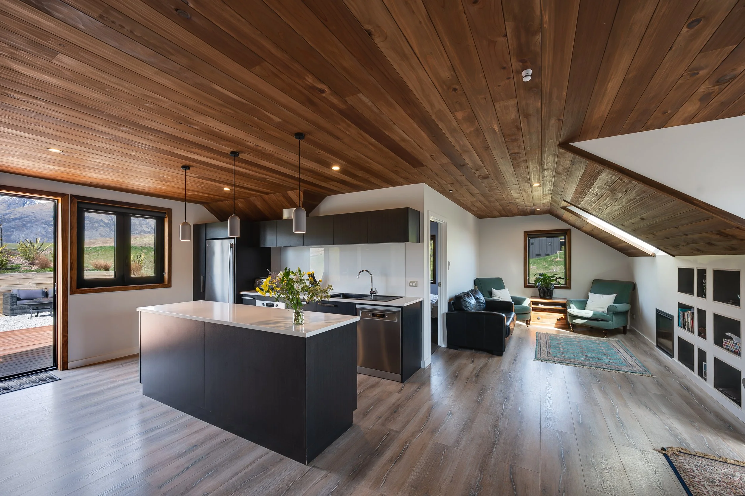 Stunning feature timber ceilings and floowing in the kitchenette and living space of the above-garage unit at a new home build in Threepwood by Diemarco Builders Queenstown.