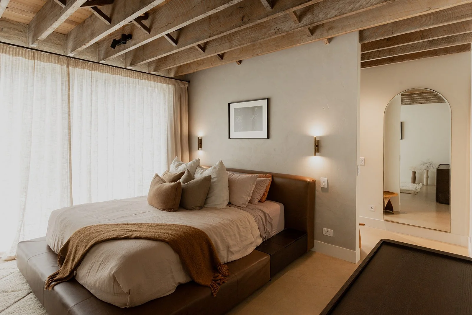 A stunning bedroom space with feature timber ceilings in a home built by Diemarco Builders Queenstown.