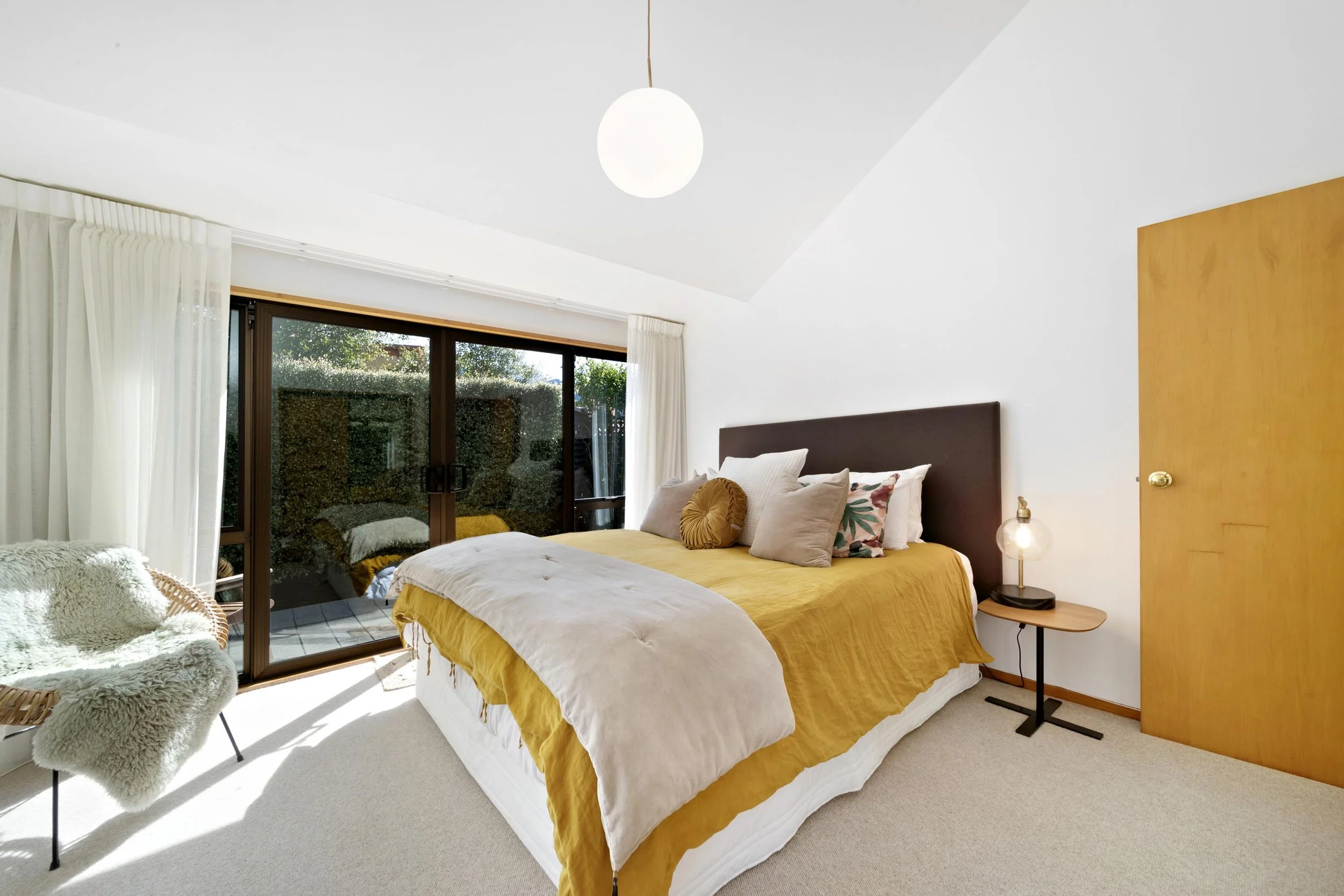 A high ceiling double bedroom with fresh new light walls at a residential renovation in Kelvin Heights by Diemarco Builders Queenstown.