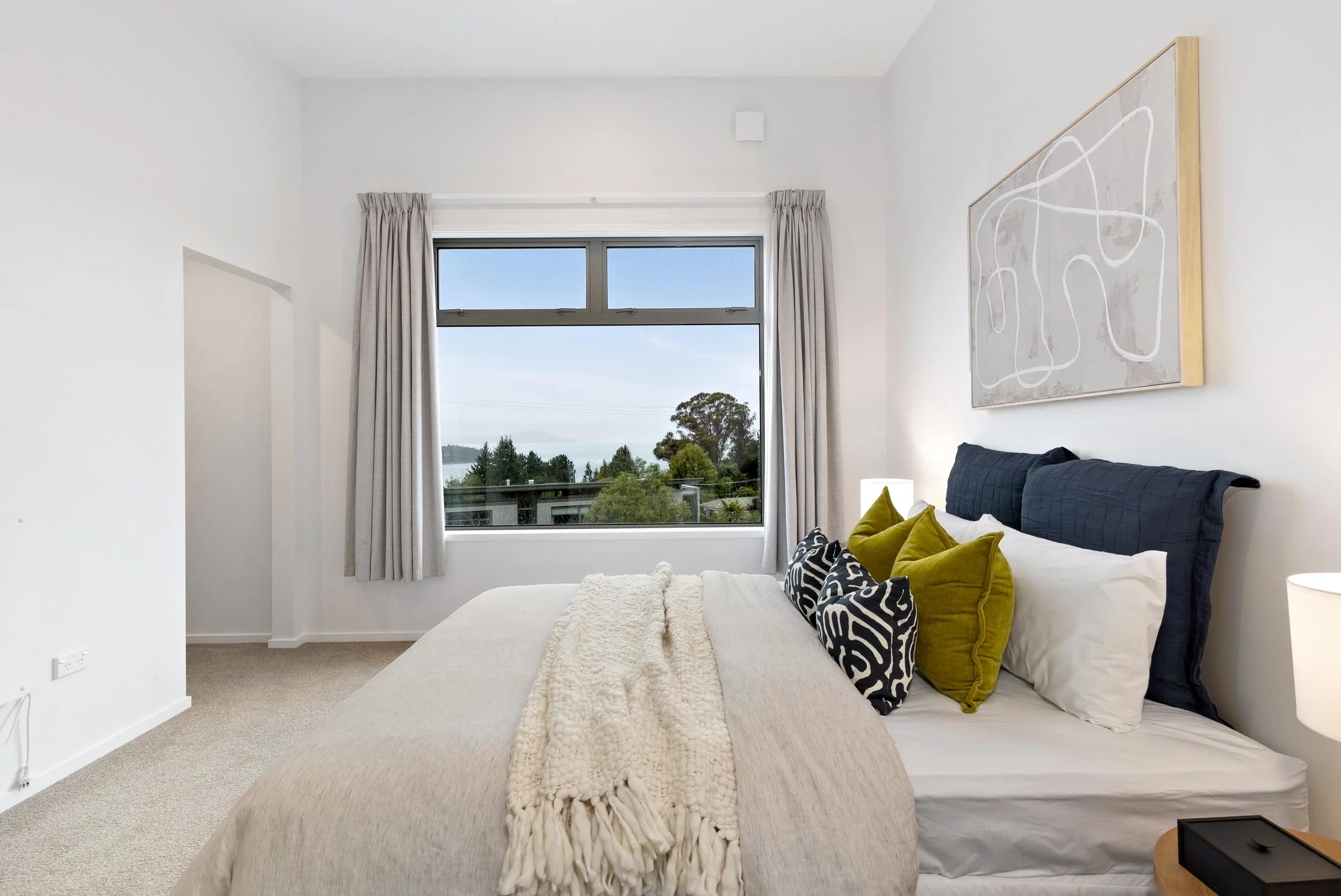 A light, crisp and inviting bedroom in a renovated townhouse by the team at Diemarco Builders Queenstown.