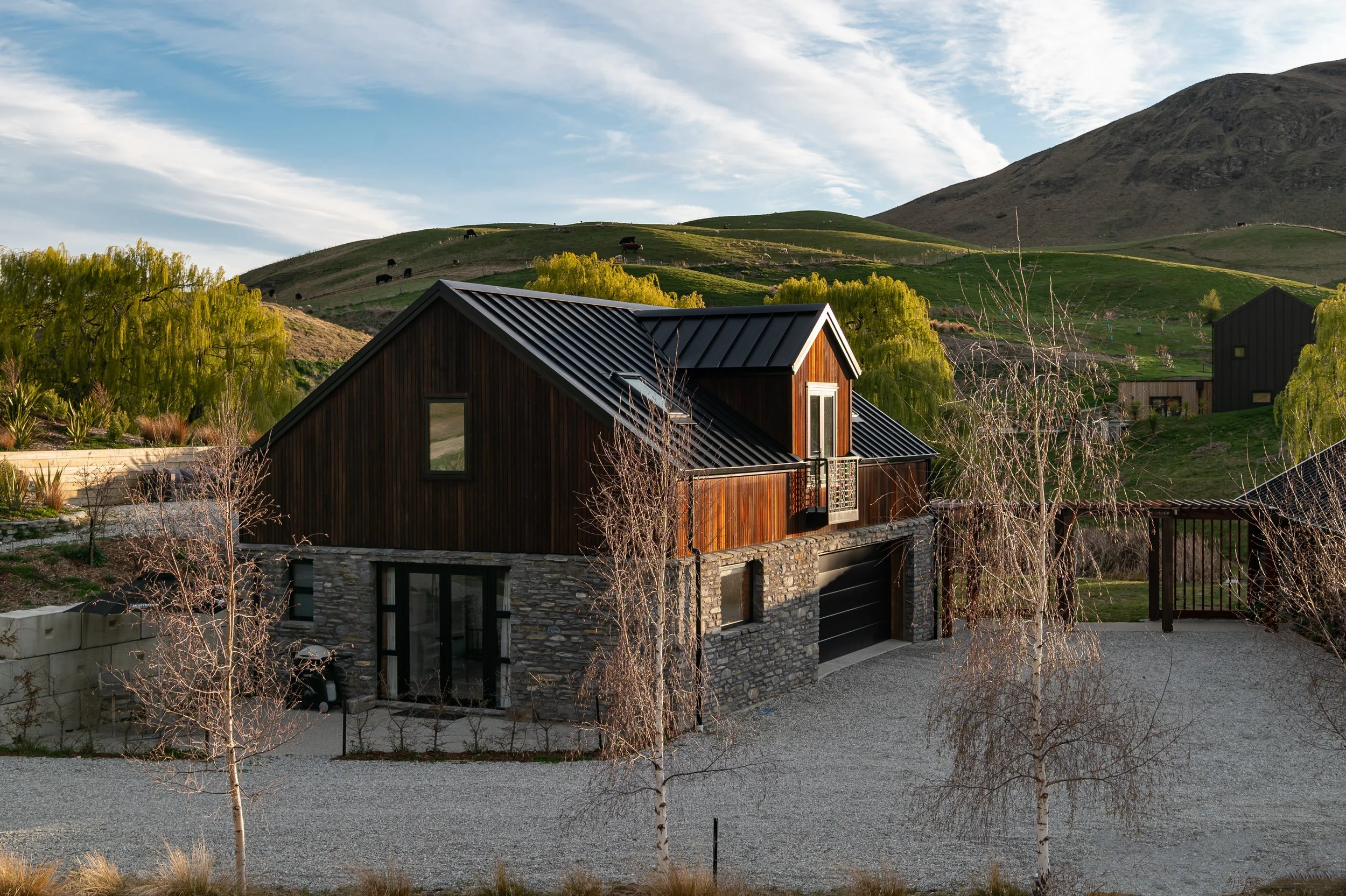 The stone clad garage with second story timber unit built on top at a new home build in Threepwood by Diemarco Builders Queenstown.