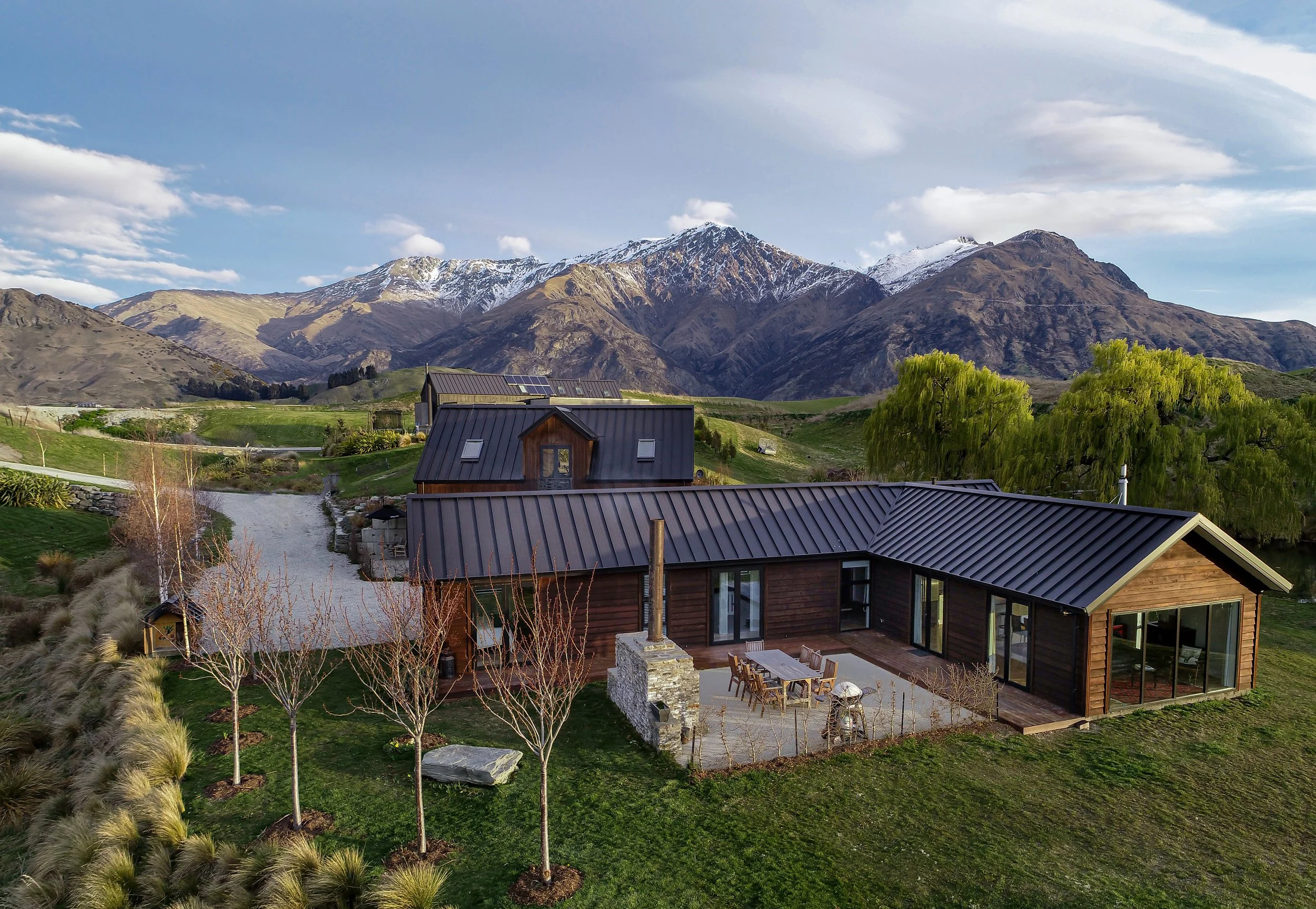 The front view of the timber clad home with the mountains in the background at a new home build in Threepwood by Diemarco Builders Queenstown.