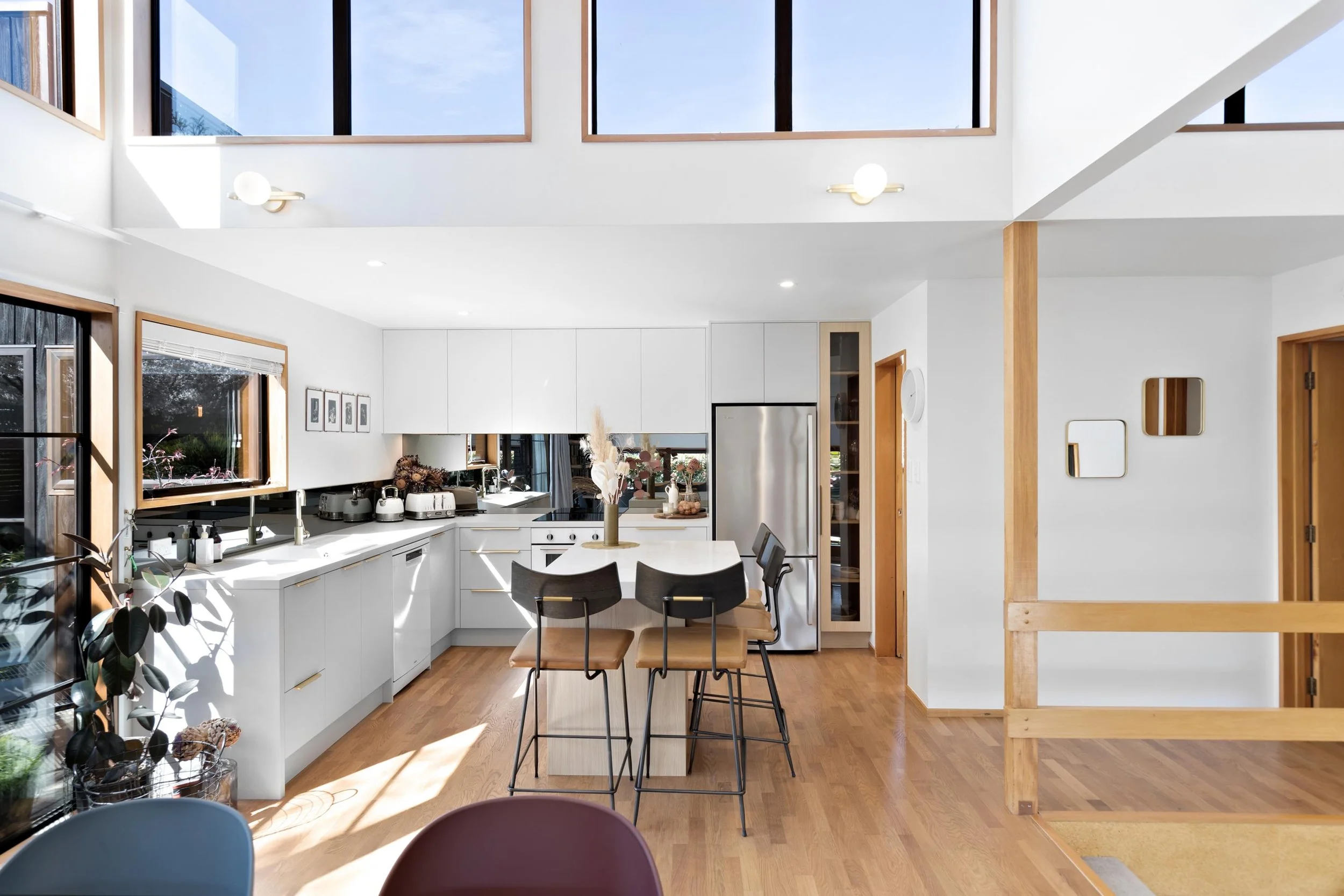 A fresh new white kitchen with big feature windows above at a residential renovation in Kelvin Heights by Diemarco Builders Queenstown.
