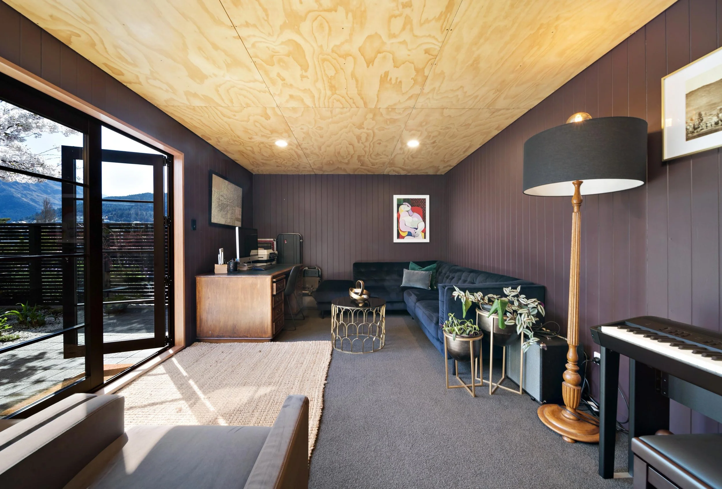 A dark and cosy media room/secondary lounge at a residential renovation in Kelvin Heights by Diemarco Builders Queenstown.