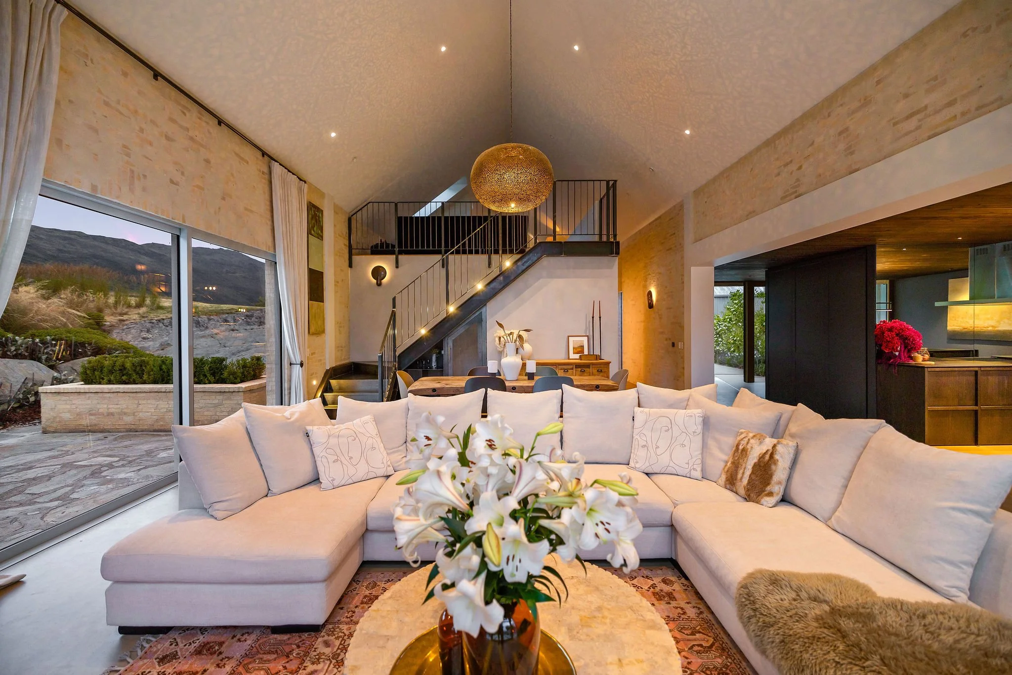 The large spacious open ceiling living area looking towards the stairway to a loft space at Peregine Ridge, a Gibbston Valley home built by Diemarco Builders Queenstown.