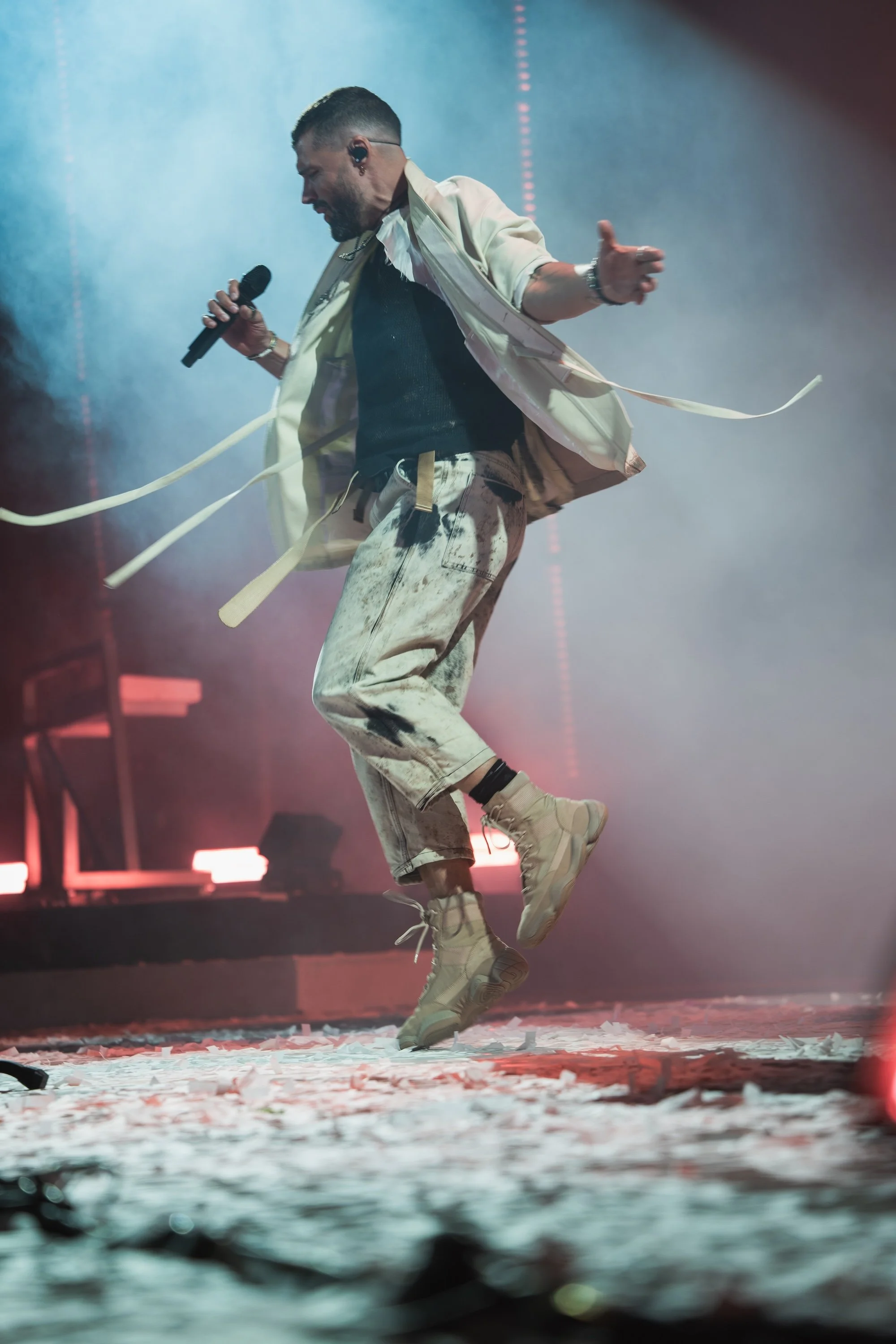 A man performing energetically on stage in Kalispell, Montana in the Flathead Valley