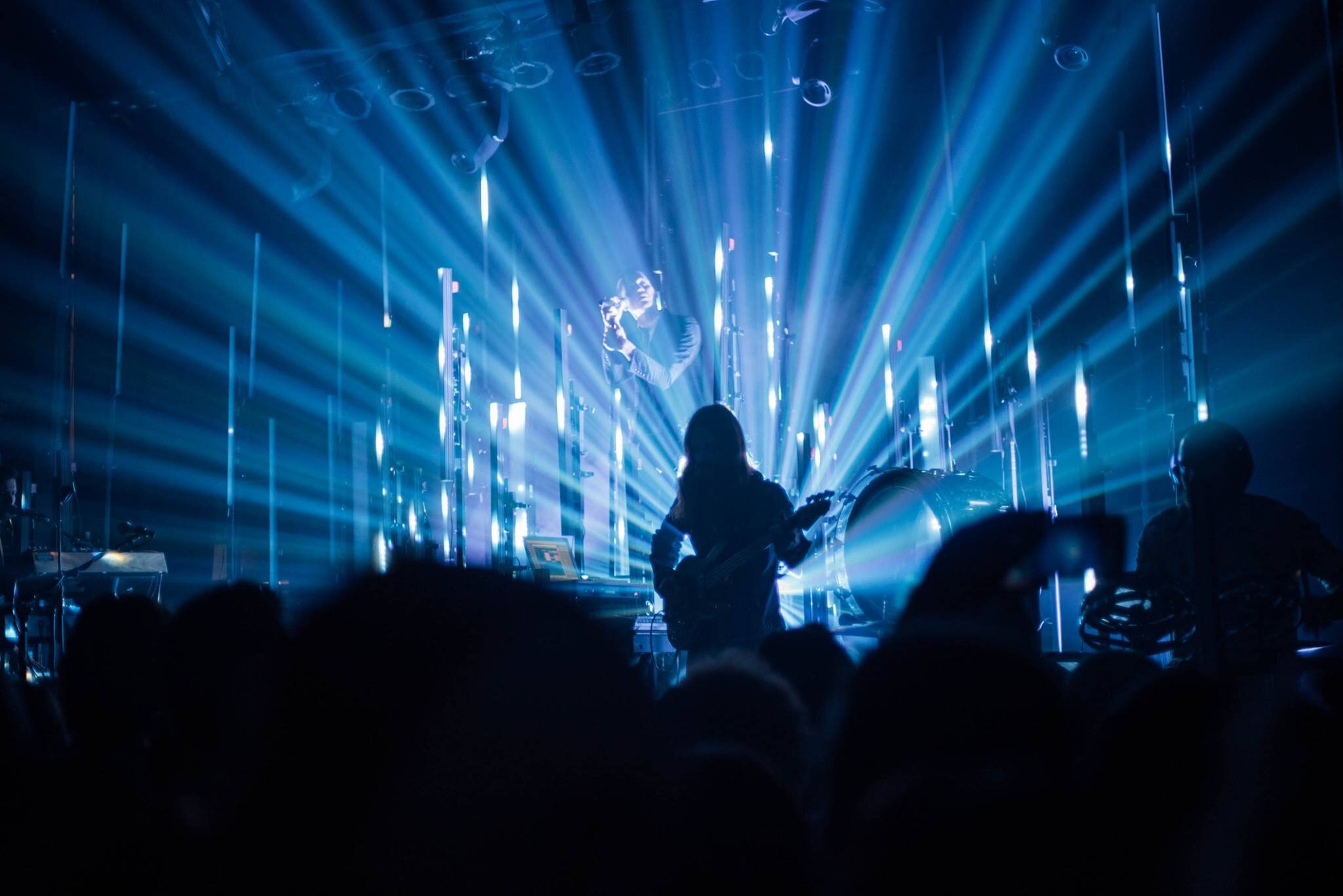 Concert scene with musicians on stage and blue light beams in Kalispell, Montana in the Flathead Valley