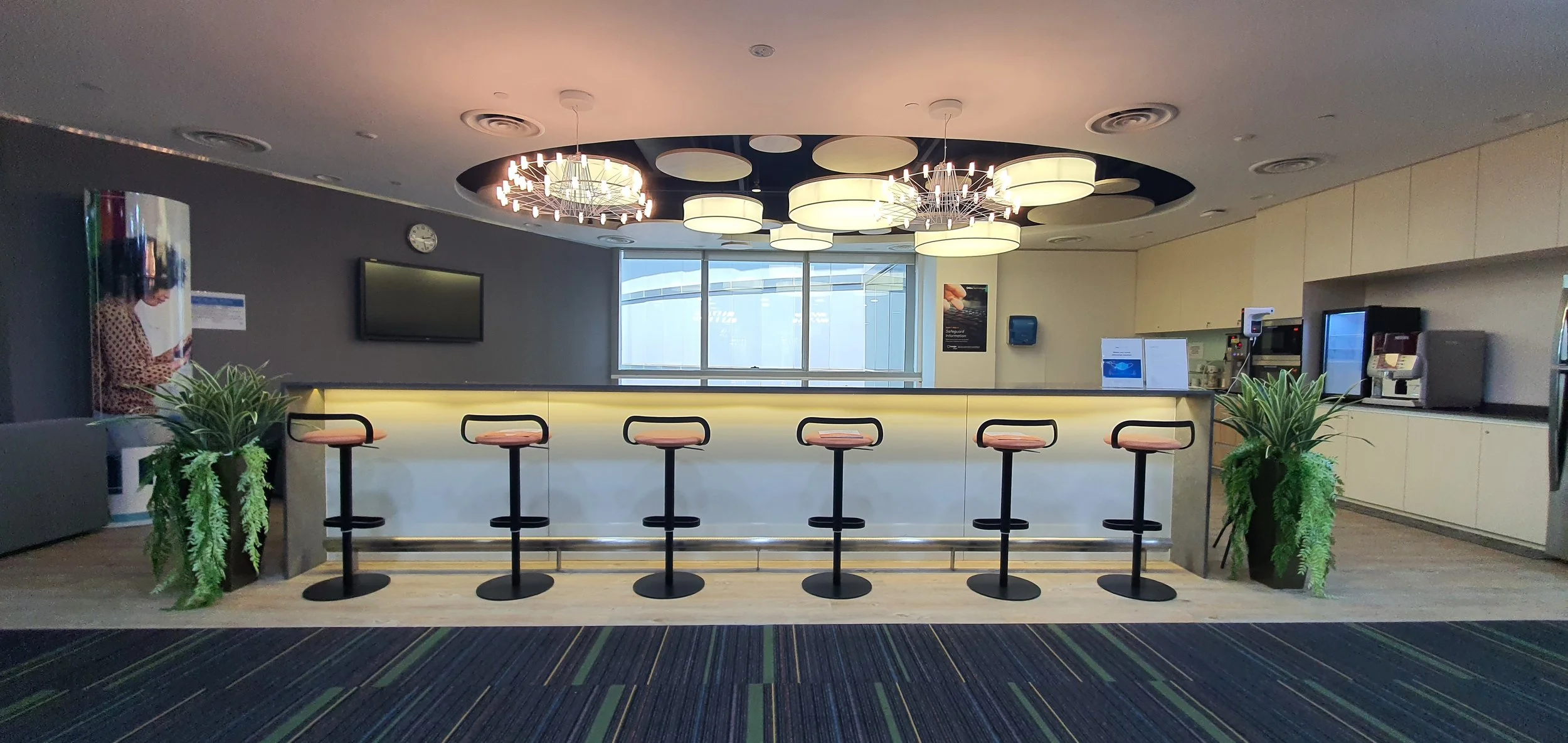 Office pantry with bar counter and high stools