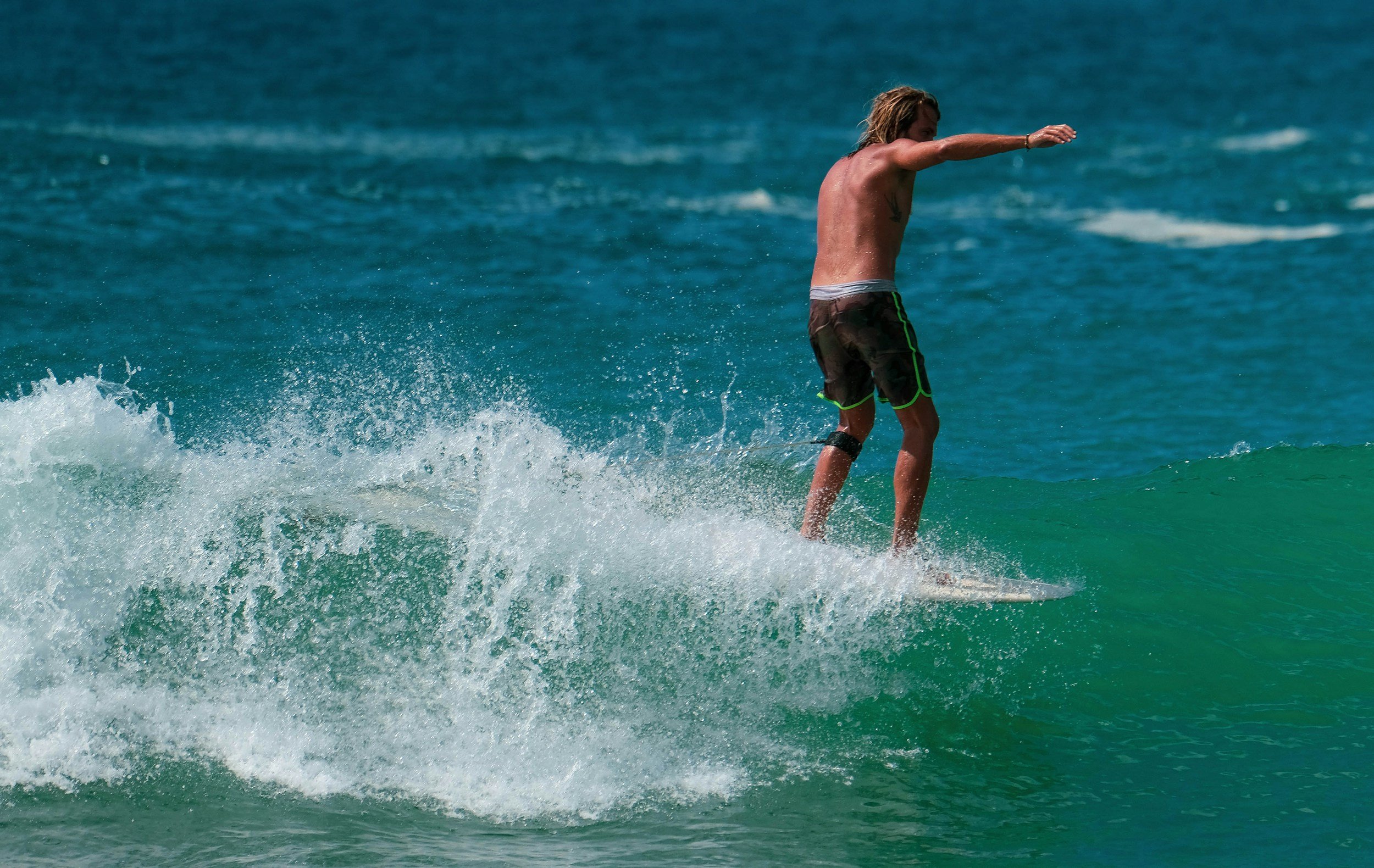 Man surfing on a wave in the ocean.