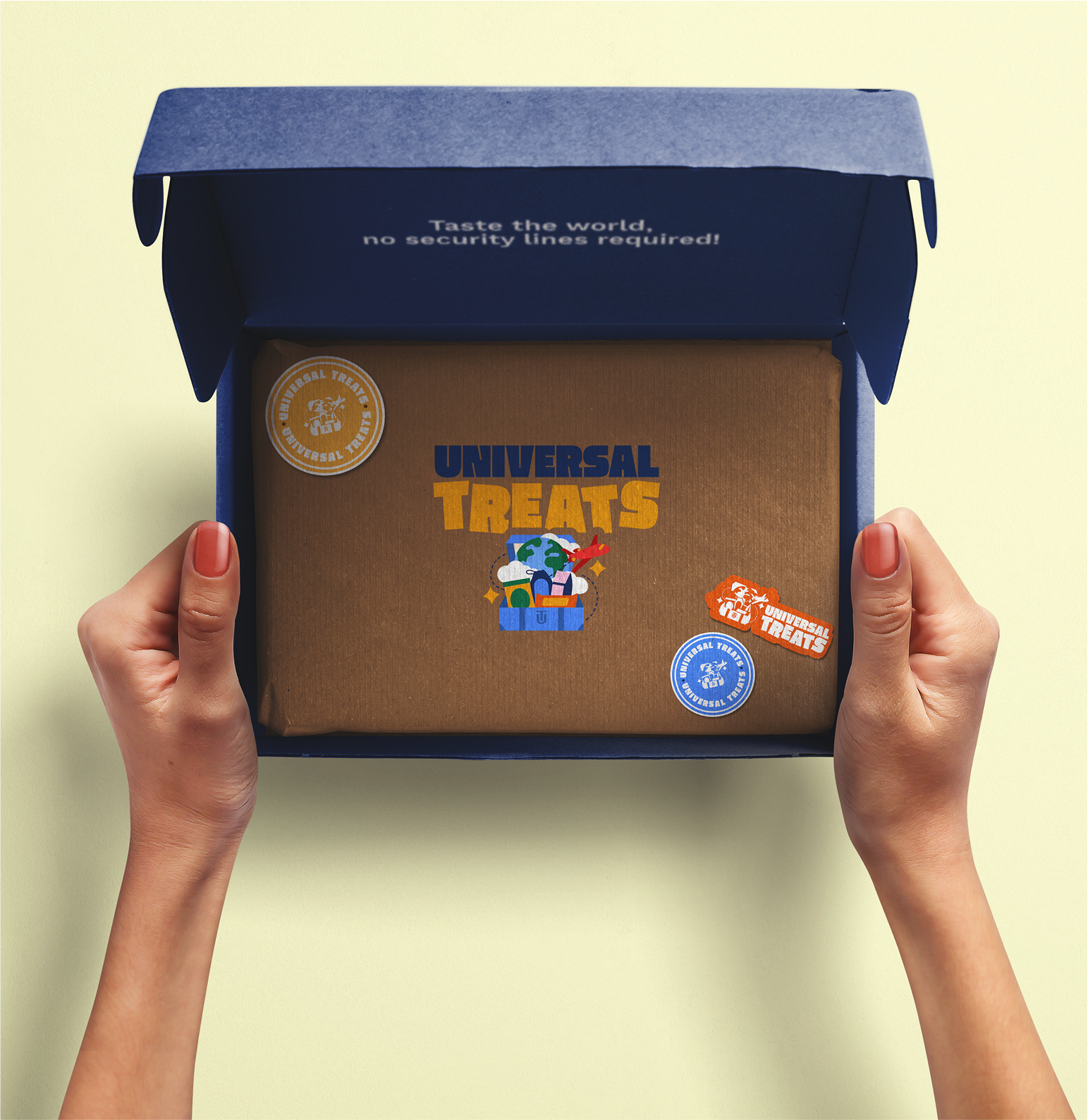 Hands holding an open box labeled "Universal Treats" with travel-themed stickers inside a blue package.