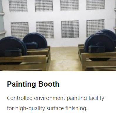 Empty painting booth with black circular paint containers and wooden benches in a well-lit room.