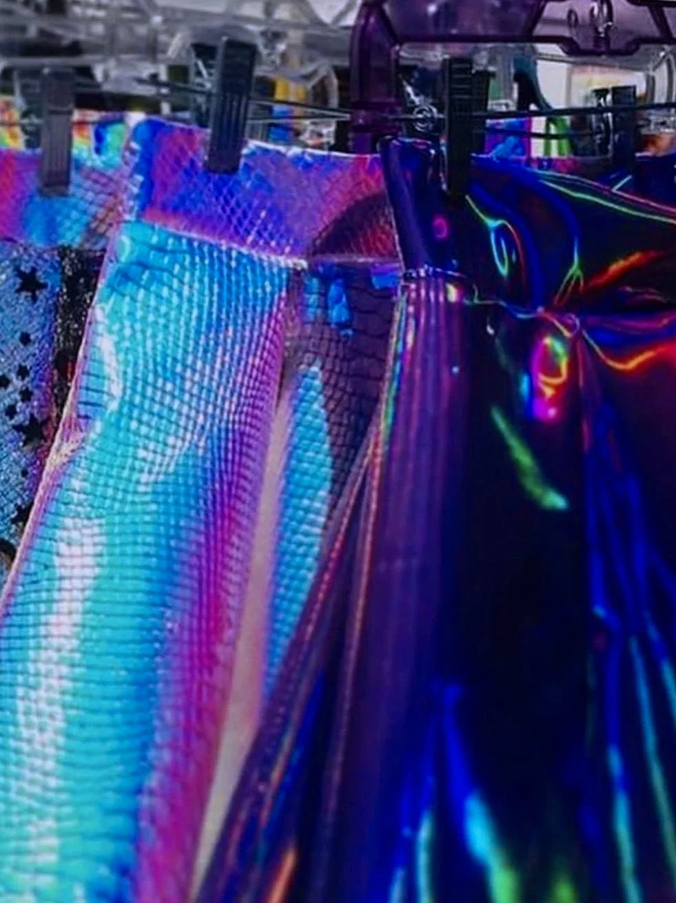 Colorful holographic fabric with rainbow sheen hanging on a clothesline