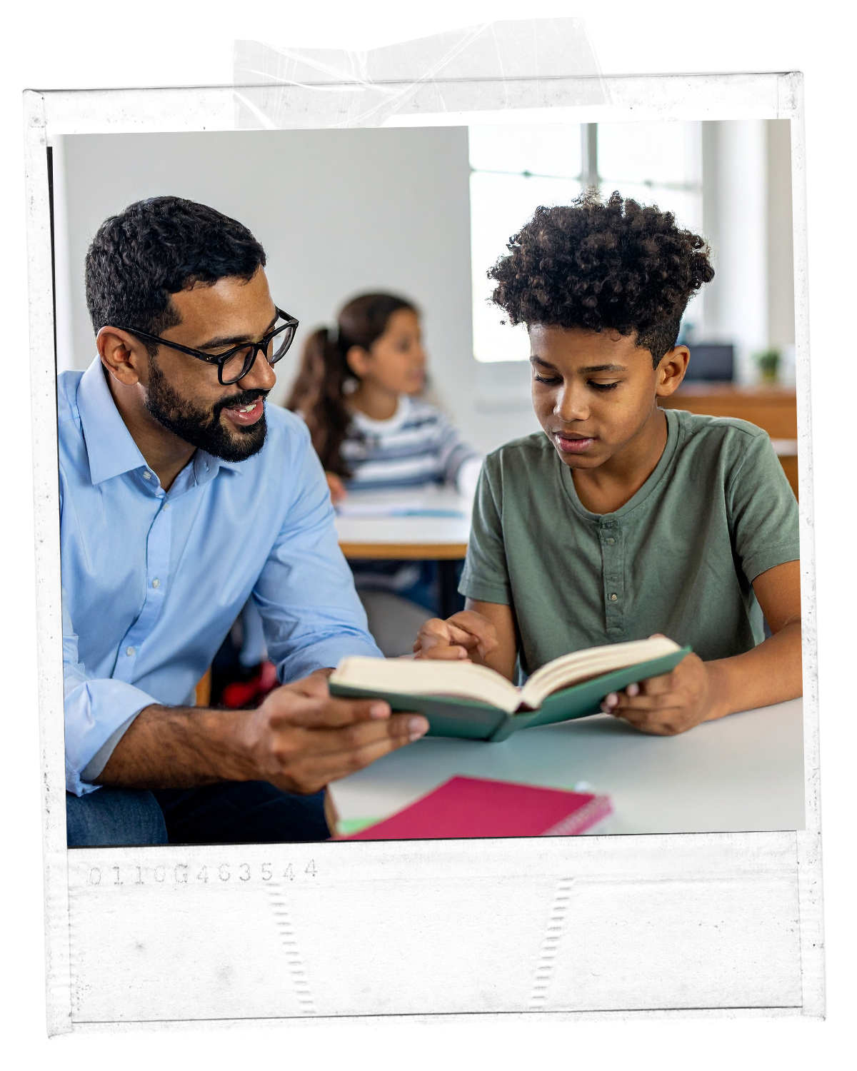 A teacher or adult helping a young boy with reading in a classroom, with a girl in the background.