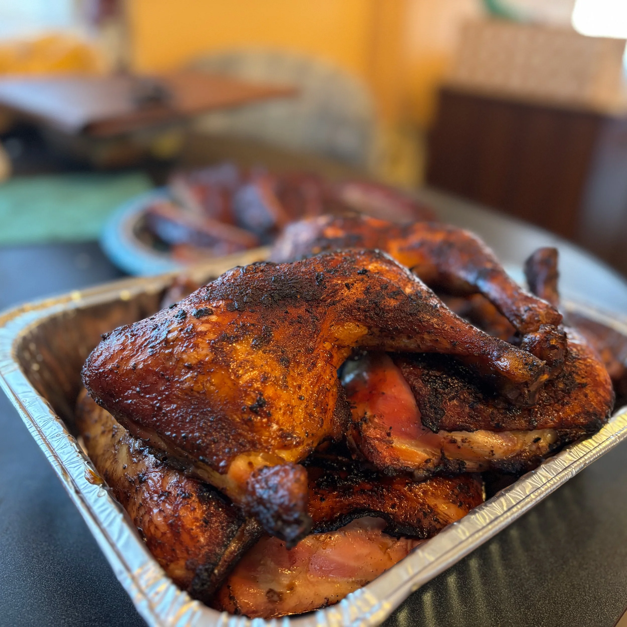 Cooked rotisserie chickens in a foil tray