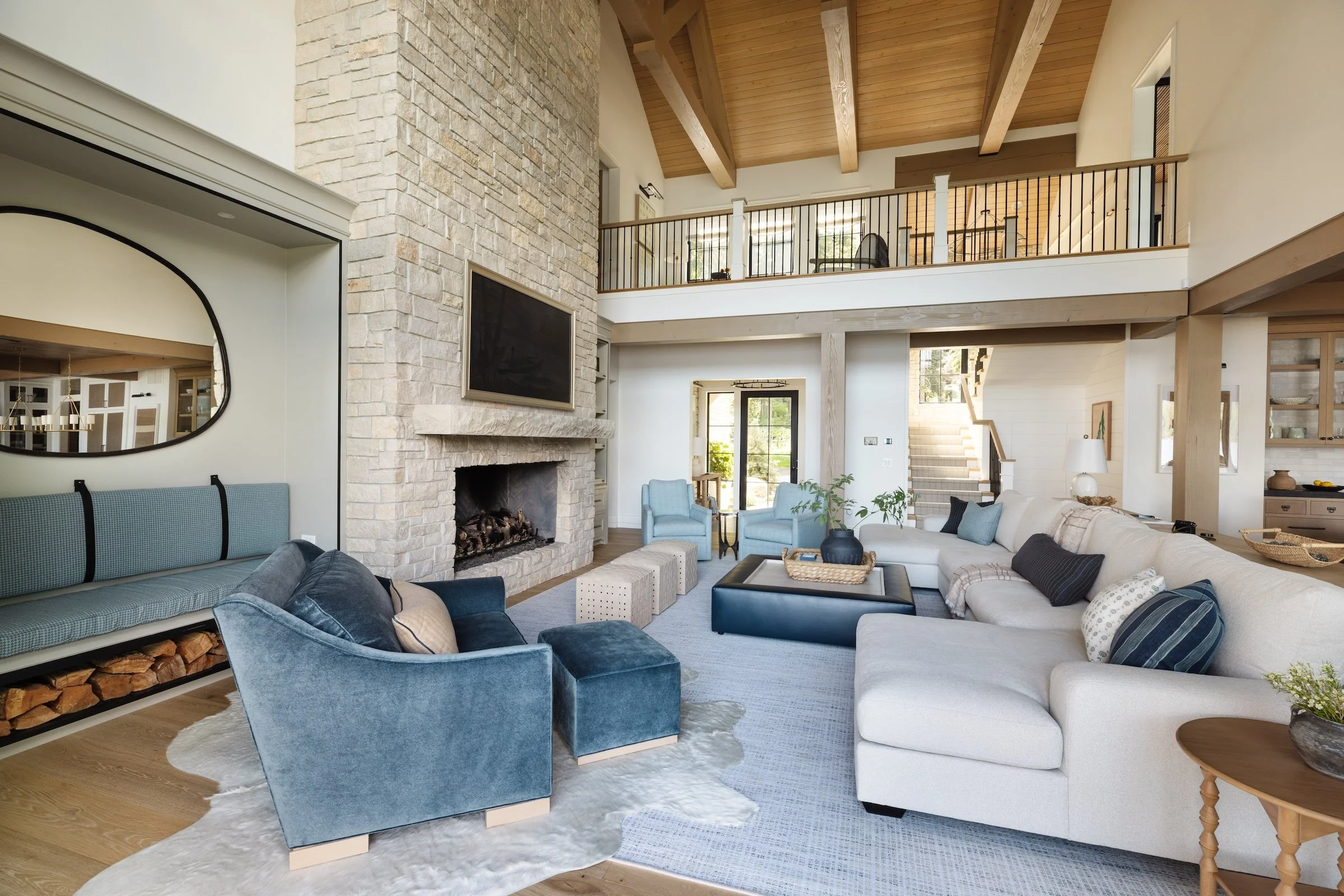 Custom finish carpentry in a McCall Idaho home featuring exposed beams, stone fireplace, and interior trim work