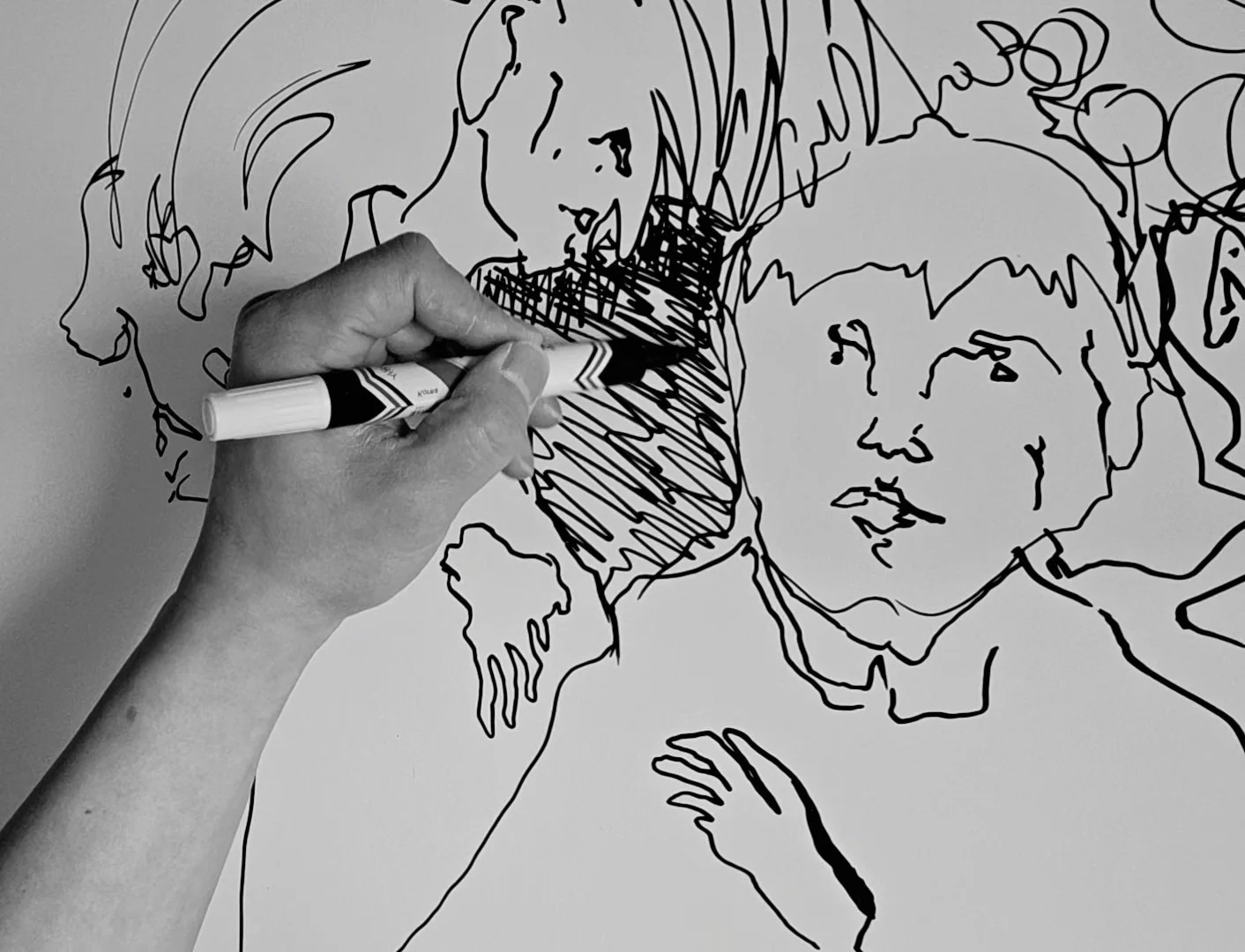 Black and white drawing of a woman with long hair, with one hand holding a marker, drawing a line sketch of herself on a large sheet of paper.