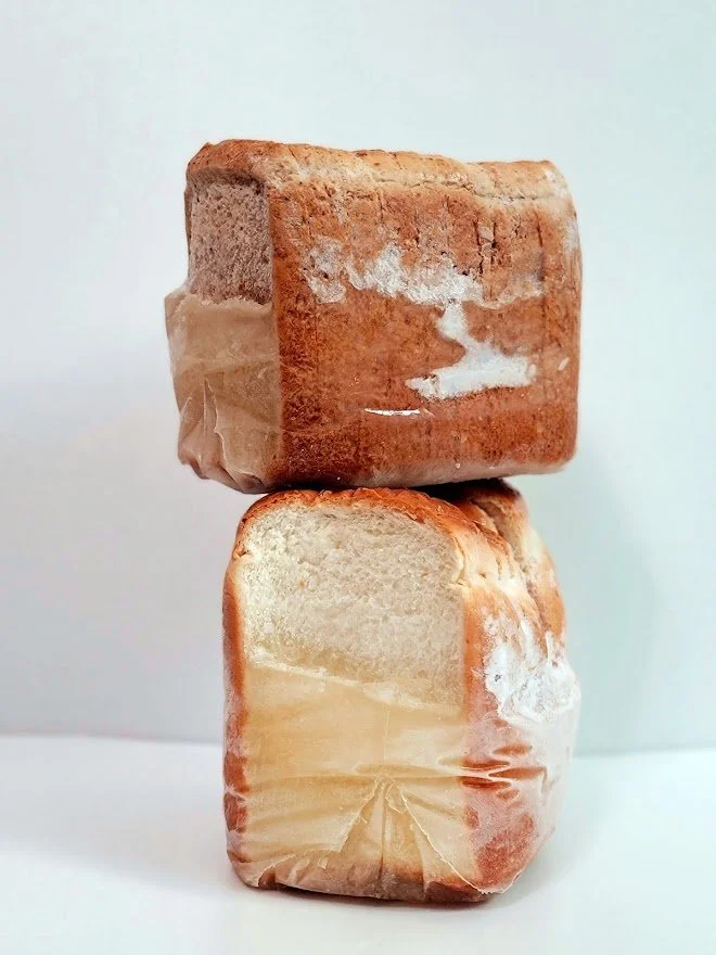 Two blocks of salted caramel fudge stacked, with the top block slightly tilted.