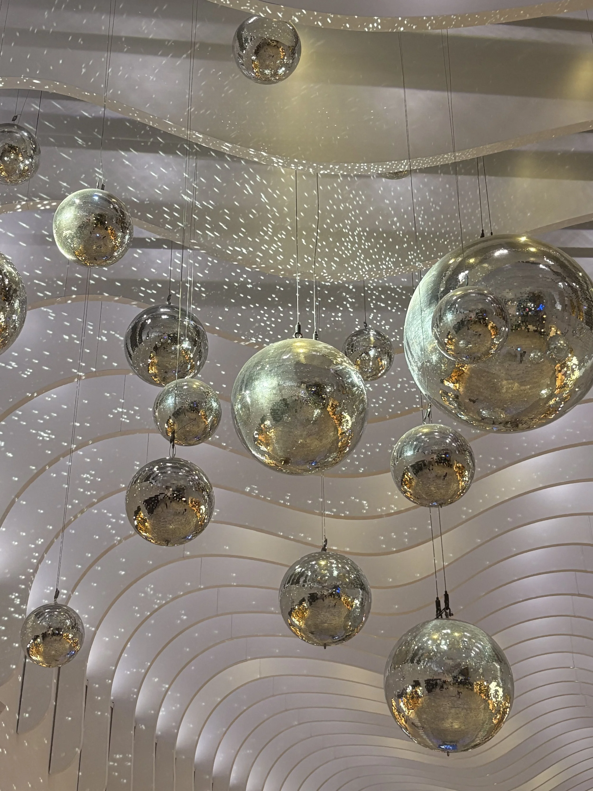 Stylish brisbane wedding reception decor with mirrored disco balls hanging from ceiling
