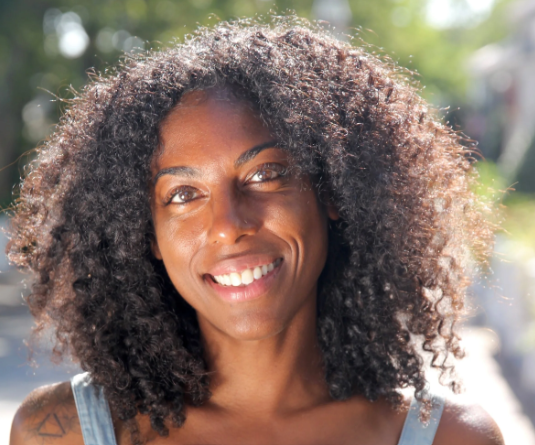 Smiling woman with curly hair outdoors