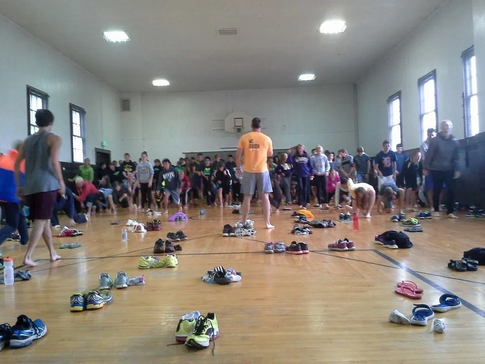 People in a gymnasium participating at Fort Casey Running Camp - Youth Running Camp