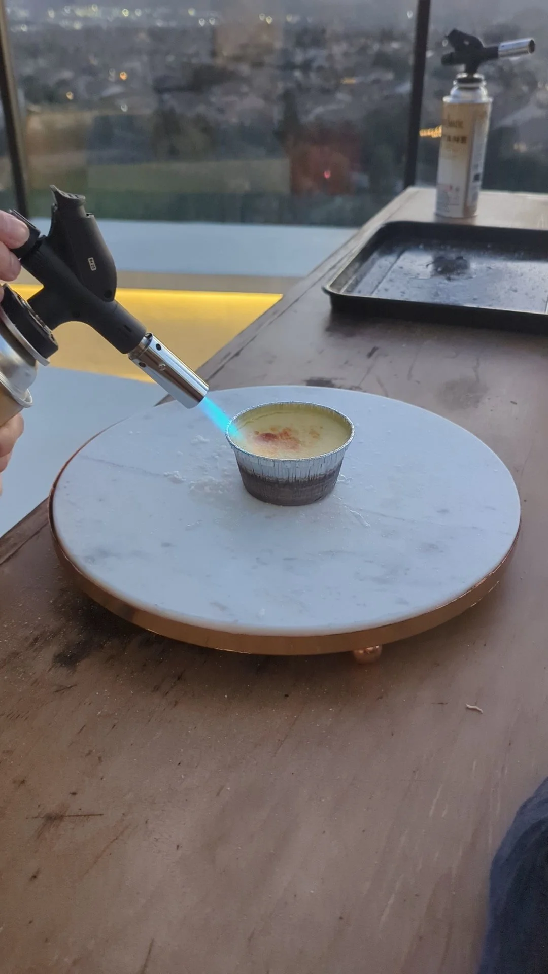 Torch caramelizing sugar crust on crème brûlée dessert
