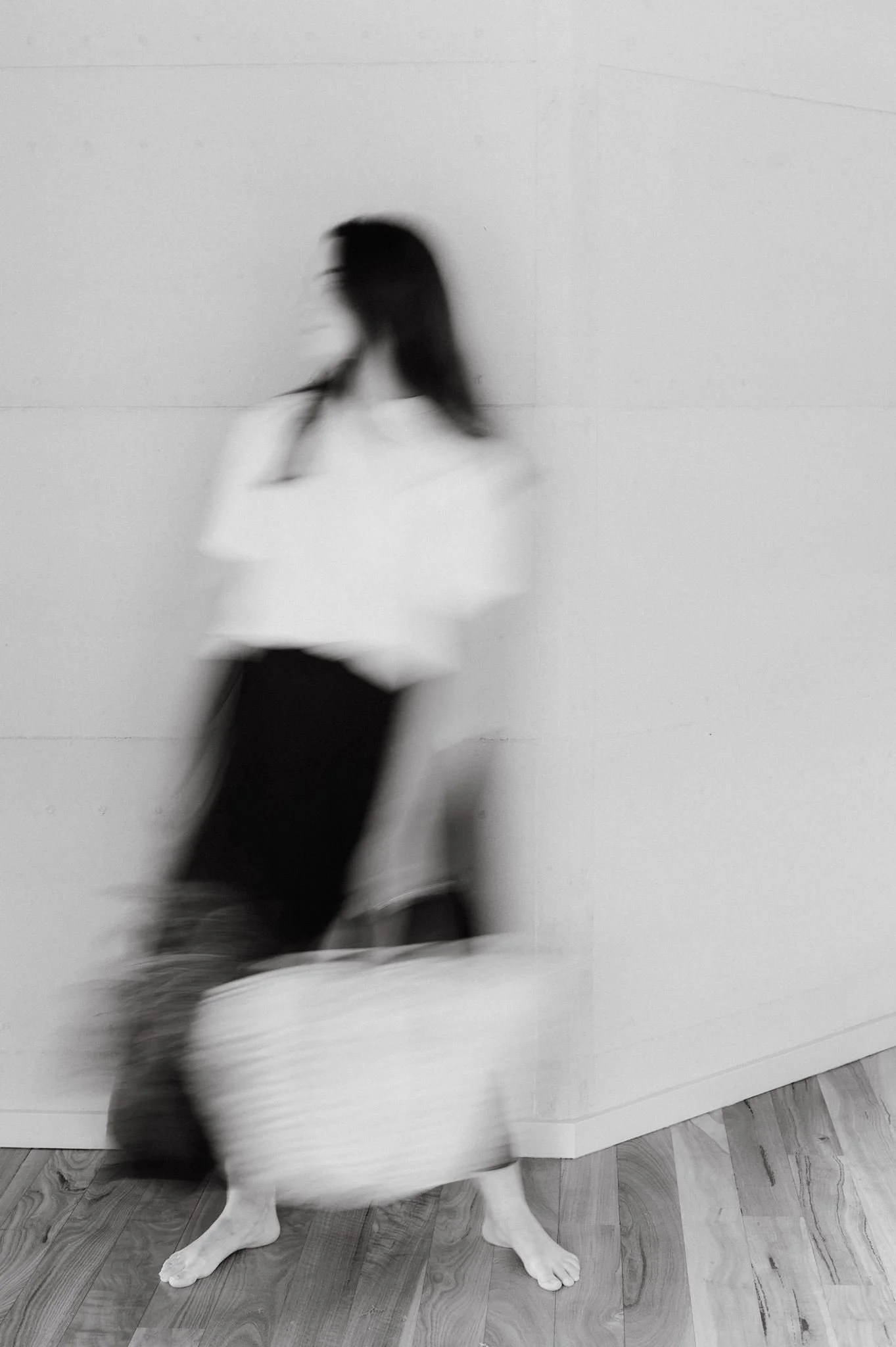 Black and white photo of a woman with a French market bag full of produce.