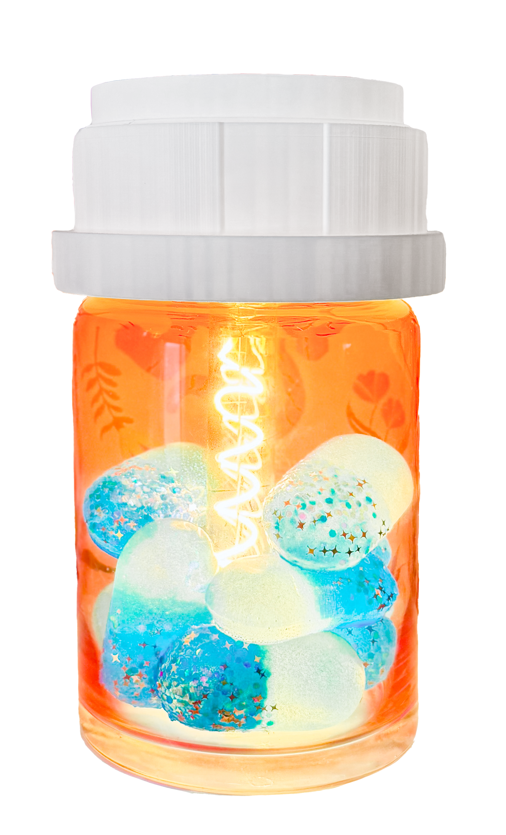 A transparent orange giant pill bottle lamp capsule-shaped container filled with colorful iridescent marbles and glitter, with a white LED light string inside.
