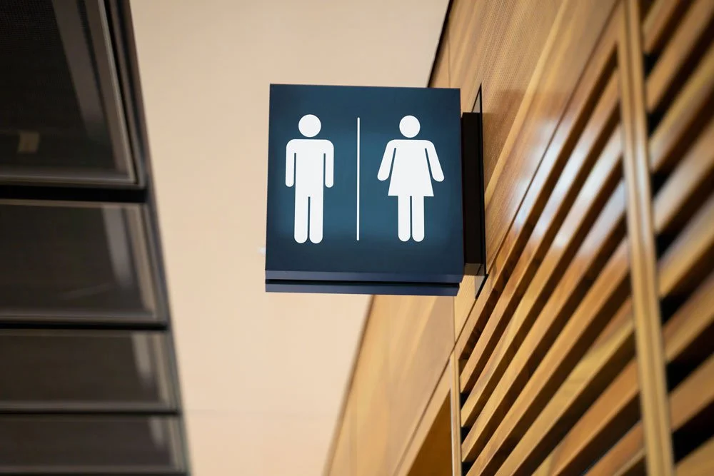 Men's and women's restroom signs hanging on the wall.
