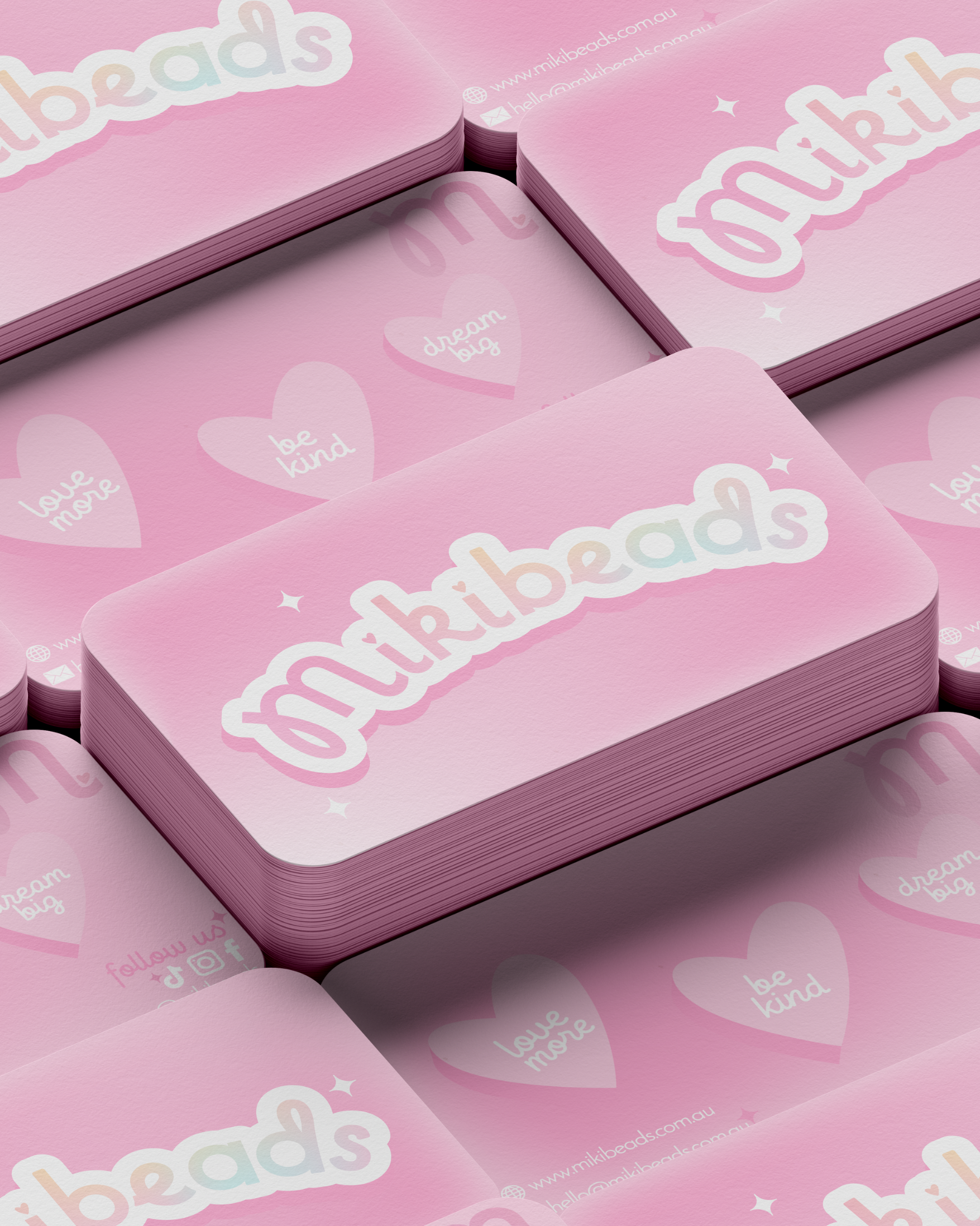 Stack of pink greeting cards featuring the word "beads" in a playful, pastel-colored font, with additional decorative hearts and stars, on a matching pink background with similar motifs and social media icons.