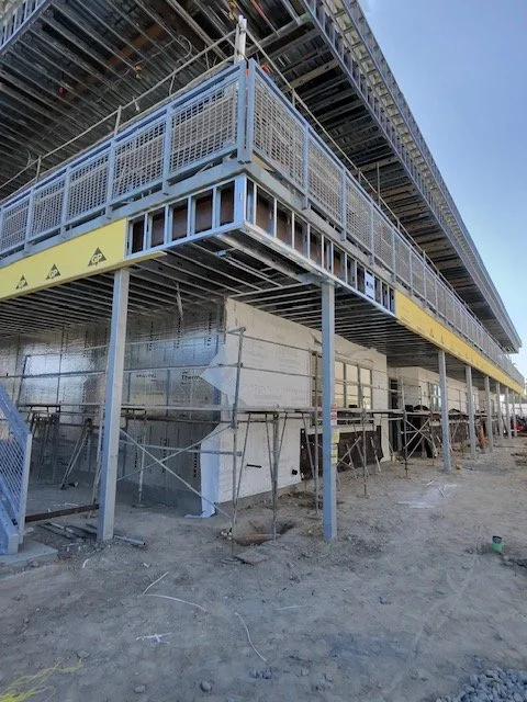 JC Insulation school exterior project showing insulated walls, steel framing, and scaffolding