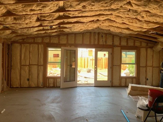 Residential room with insulation installed in wood-frame walls and ceiling