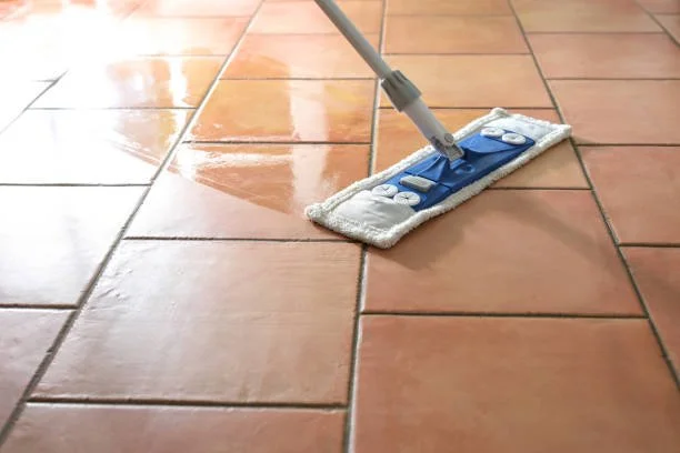 A mop cleaning terracotta tiled floor.