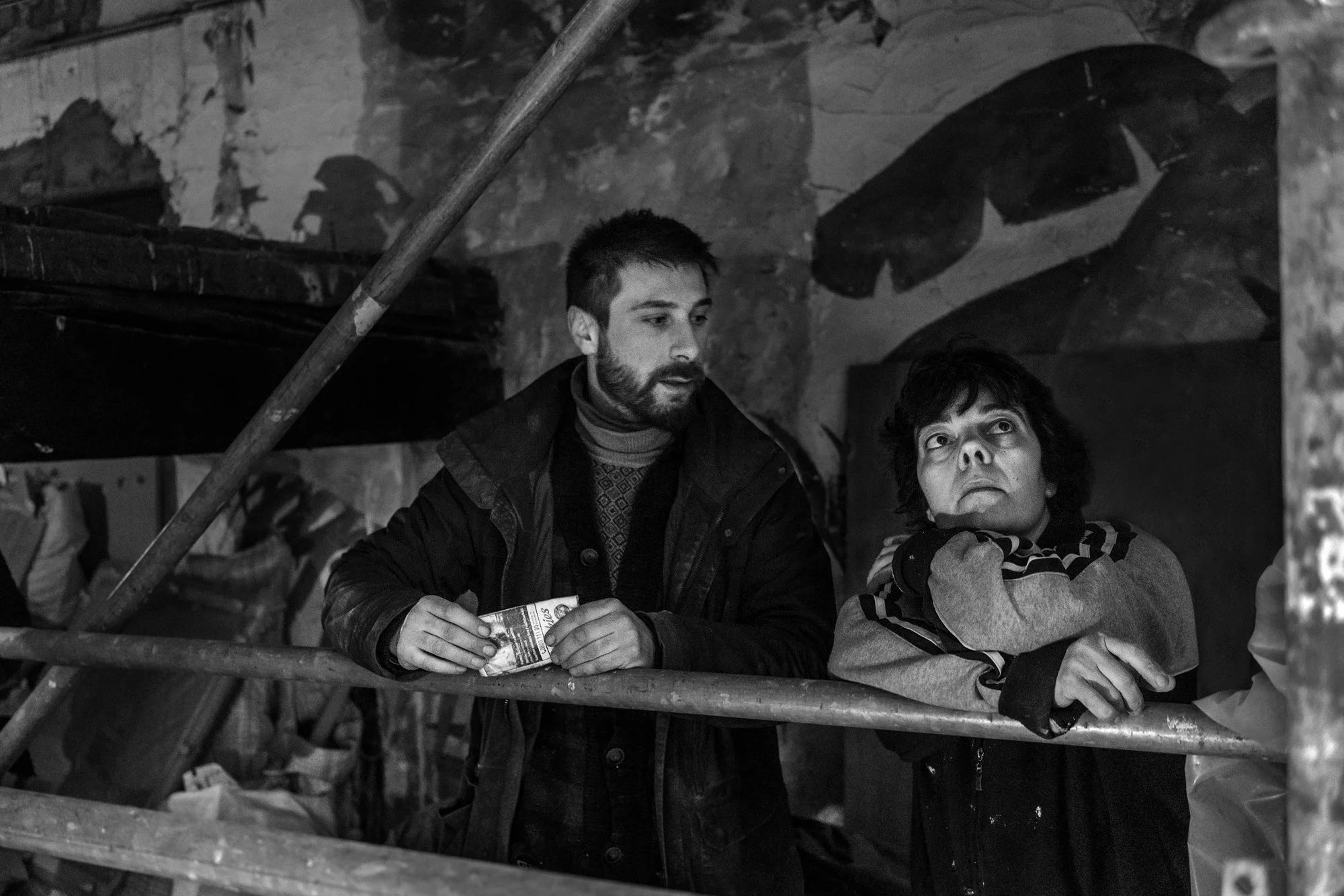 Zware interieur met twee mensen, man en vrouw, in een oude of industrieel gebouw, zwart-wit, look