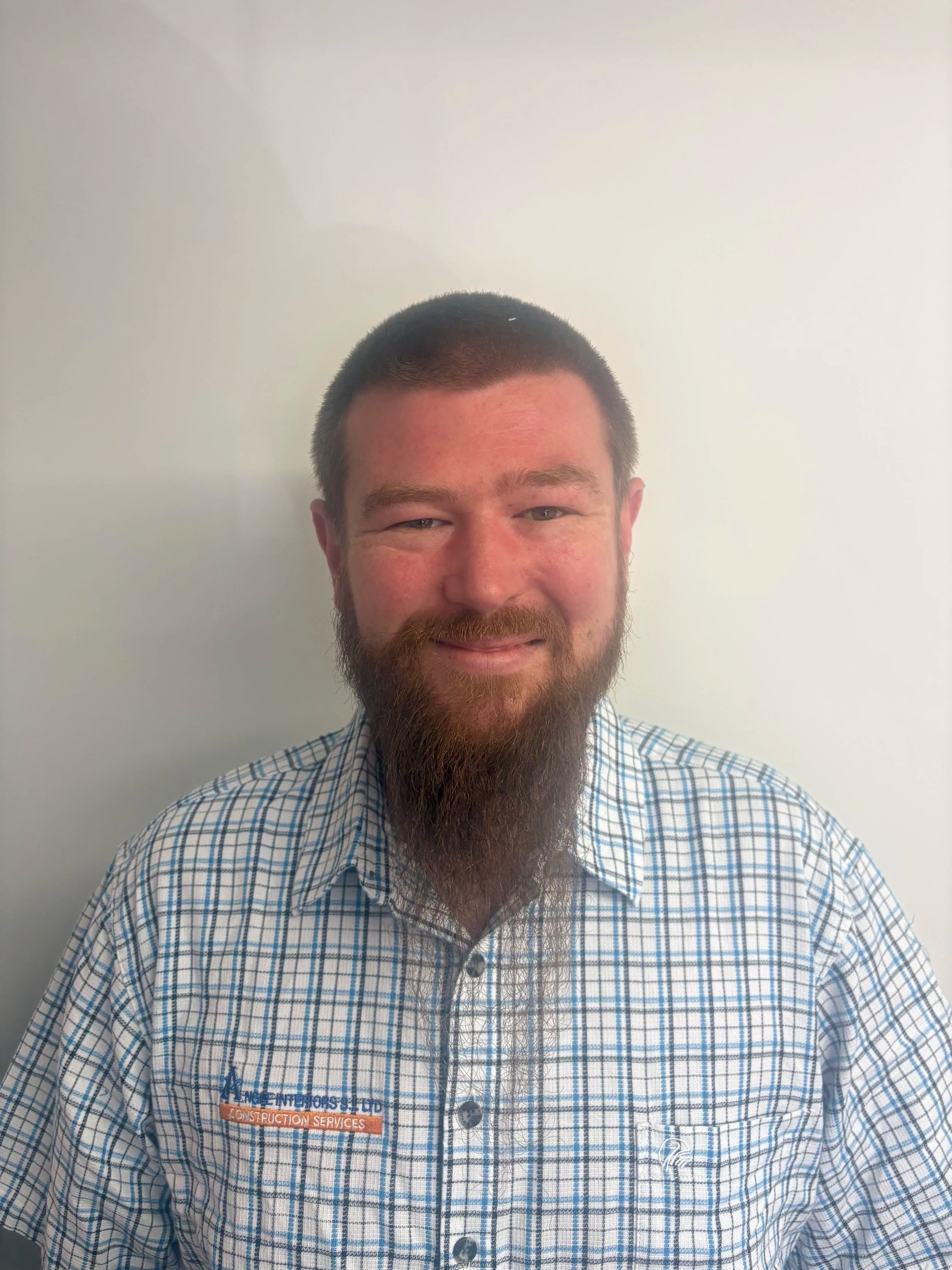 A pile of small wooden sticks with a smooth, darkened surface, arranged neatly on a white surface, casting a shadow.